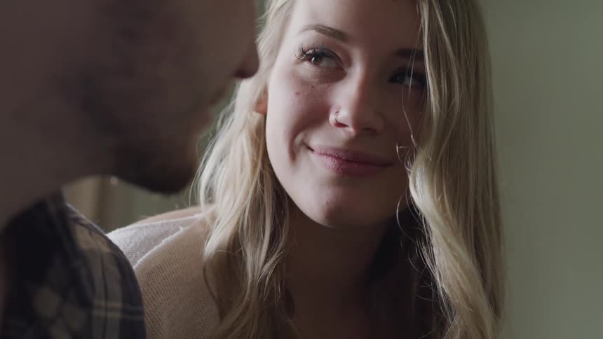 A woman looks up and smiles at a man