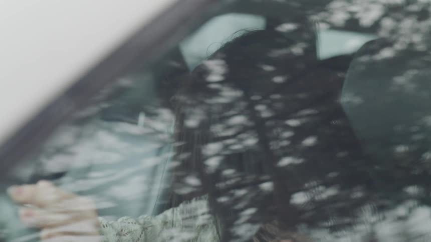 A woman shaking her head in a car