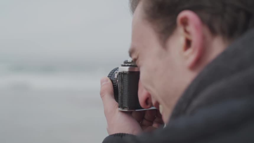 Man taking photos with an film camera at a beach
