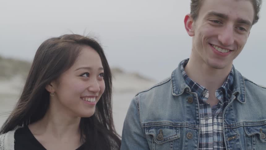 A happy couple takes a walk on a beach