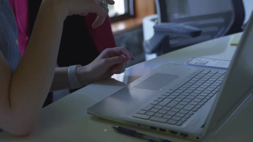 Two women look at a laptop