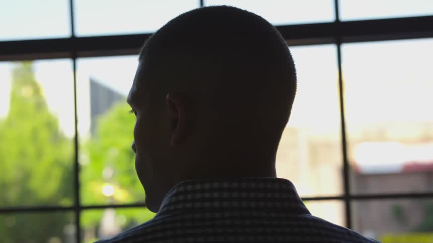 Man turns his head as he looks out the window