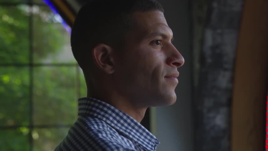 A man smiling while looking out of a window