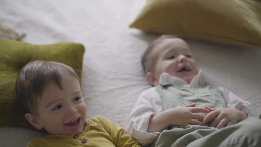 Brothers laugh and giggles as they are tickled by their mom