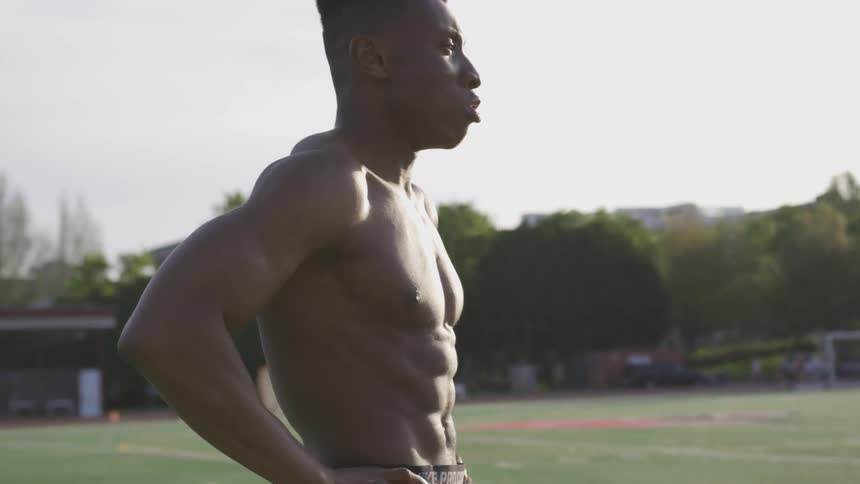 A man stretches and prepares for a workout on a field