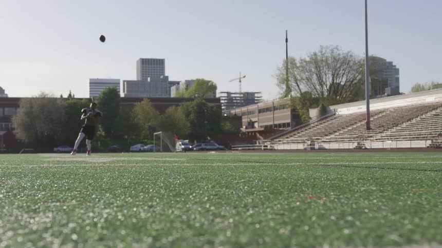 Man practicing football receives a pass