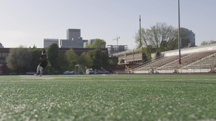A football player runs down the field to catch a throw