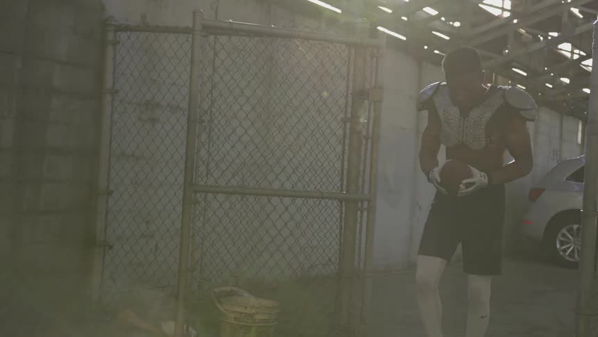 A young boy aggressively smacks a football