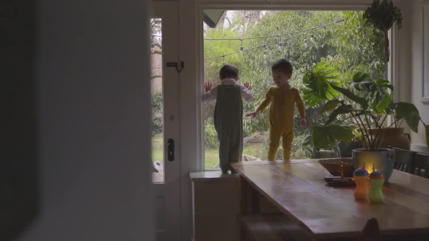 Two children walk and play on a kitchen table