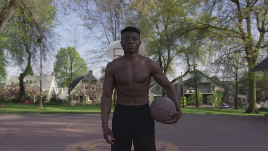 A man standing on a basketball court holding a basketball