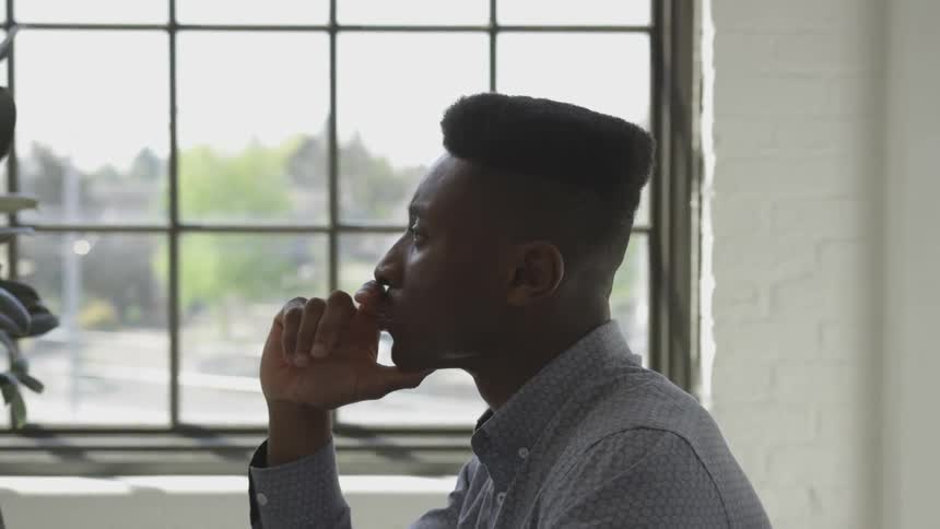 Man sits contemplating near window