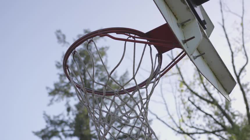 A basketball hoop and net under a clear sky