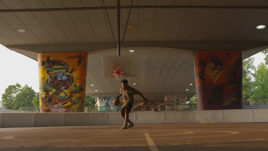 Man dribble basketball on court in pavilion