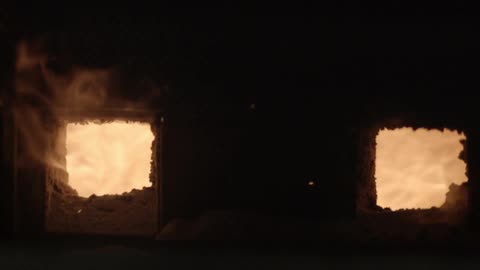 A fire burns through two portholes
