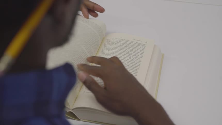 A man reads a book and turns a page