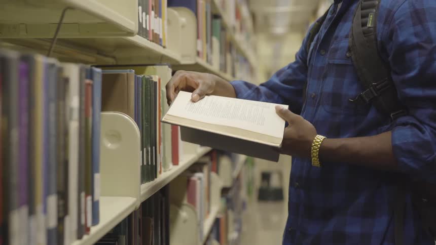 Male reading a book in a library