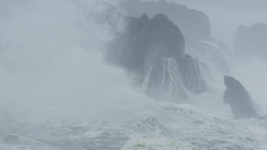 Waves crash and spray against rocks in the ocean