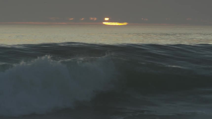 A surfer lying on his board and coasting along on waves