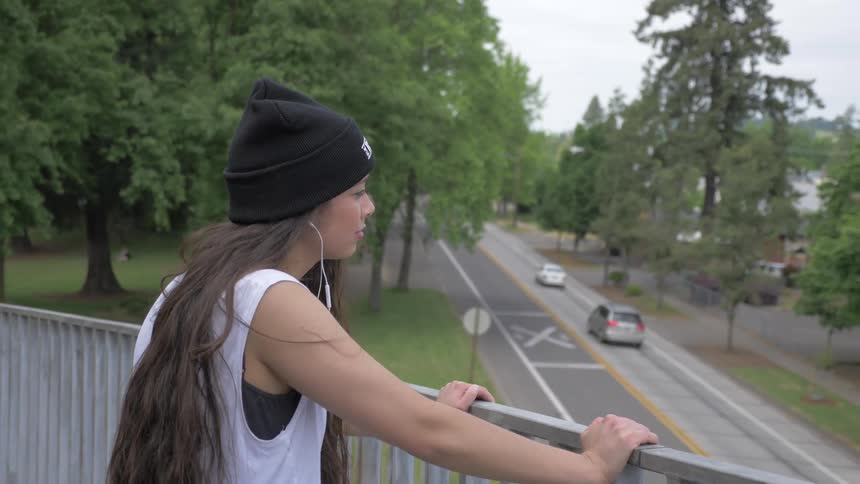 A woman standing outside looking across the road