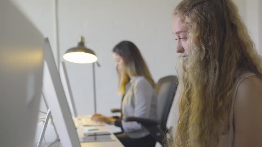 Women work on computers in office