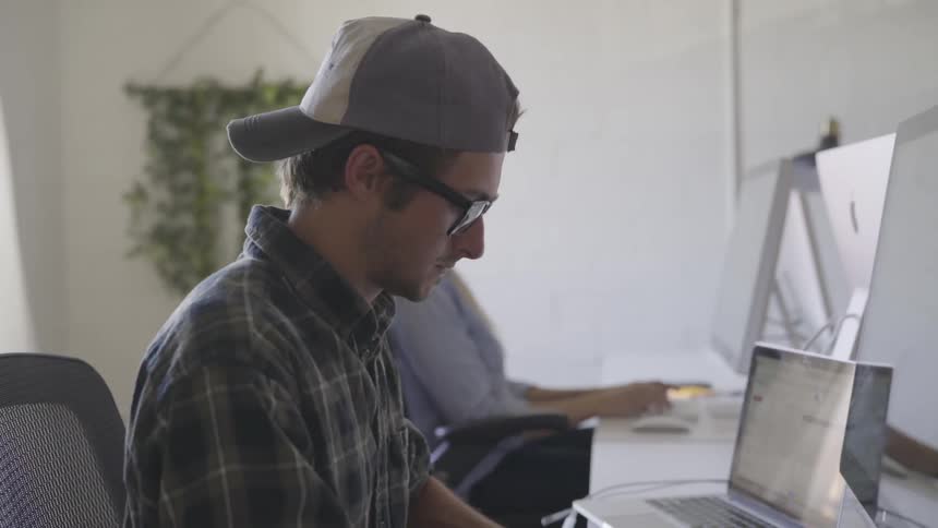 Man sitting at a desk working on a computer at the office