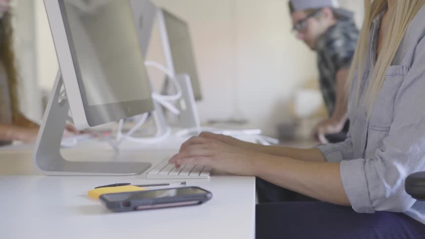 Woman sitting at a desk in office working on a computer