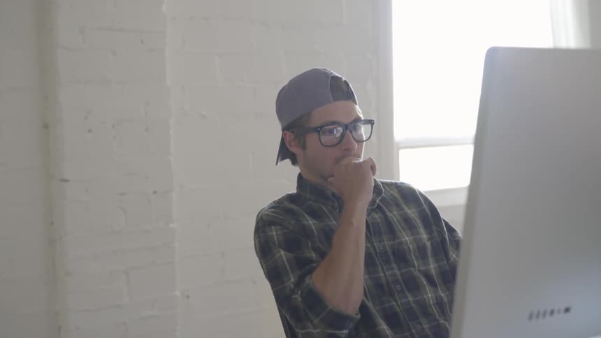 A man sitting on a chair in front of a computer