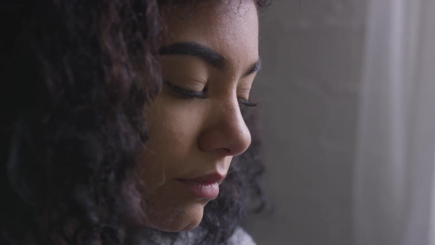 Woman with curly hair looking down