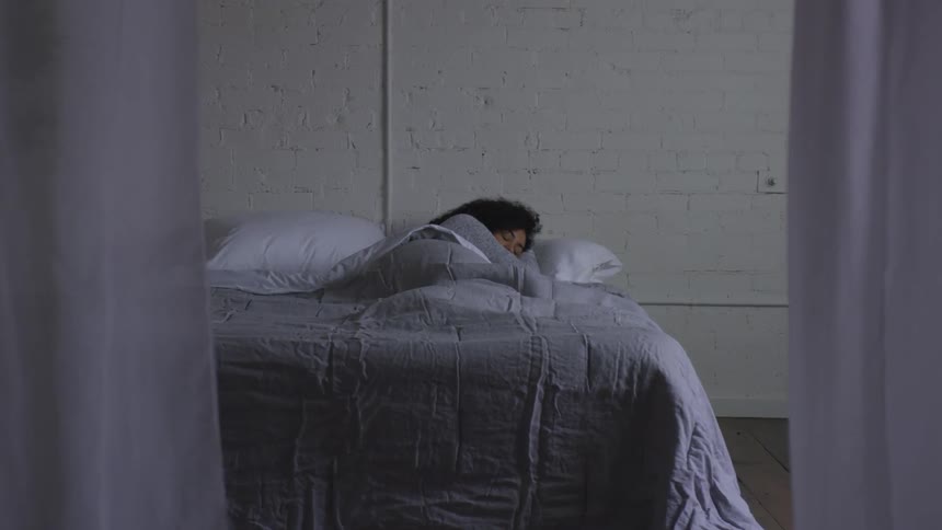 Woman laying in bed resting taking a nap