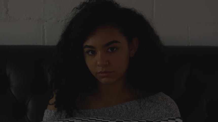 A black woman raises her eyes and looks into the distance