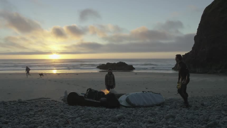A group of friends enjoy life on the coast as the sun is setting