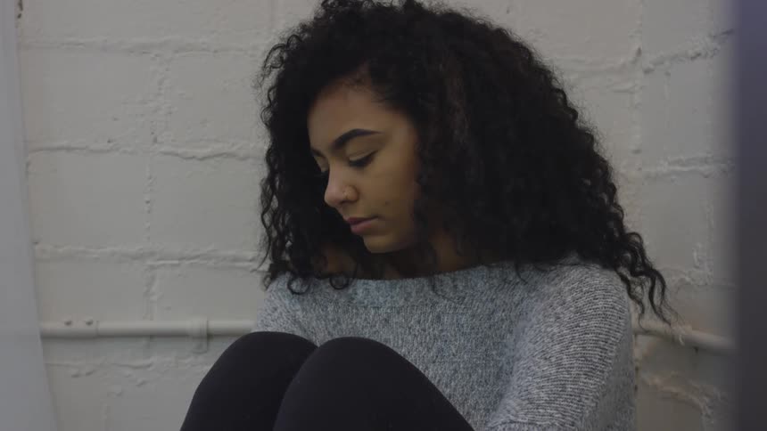 Teenager looks downward in a sad manner