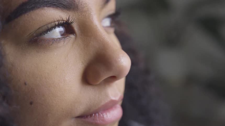A woman looks off in the distance and blinks