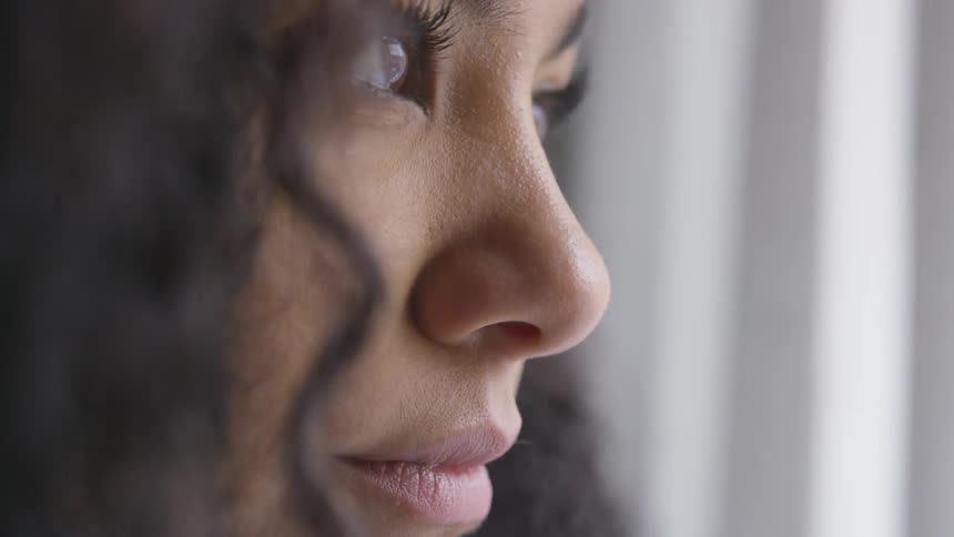 A young woman looks out a window