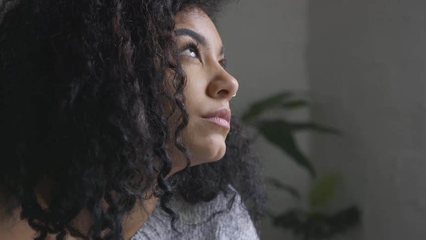 A young black girls looks in to the distance