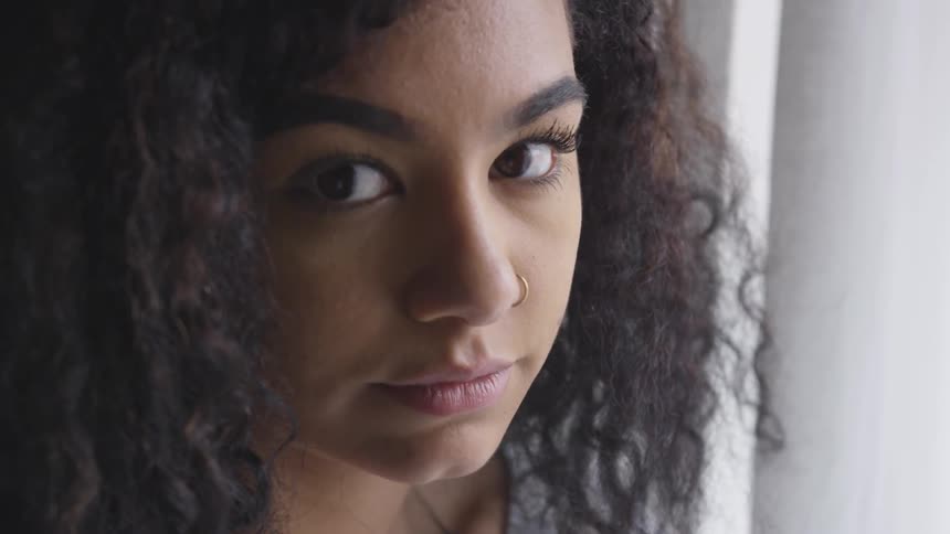 Woman with curly hair looking at the camera