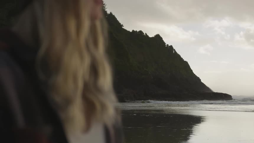 A woman stands on the beach