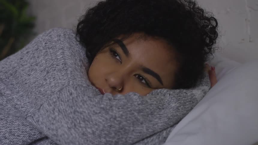 Female laying in bed slowly waking up from a nap