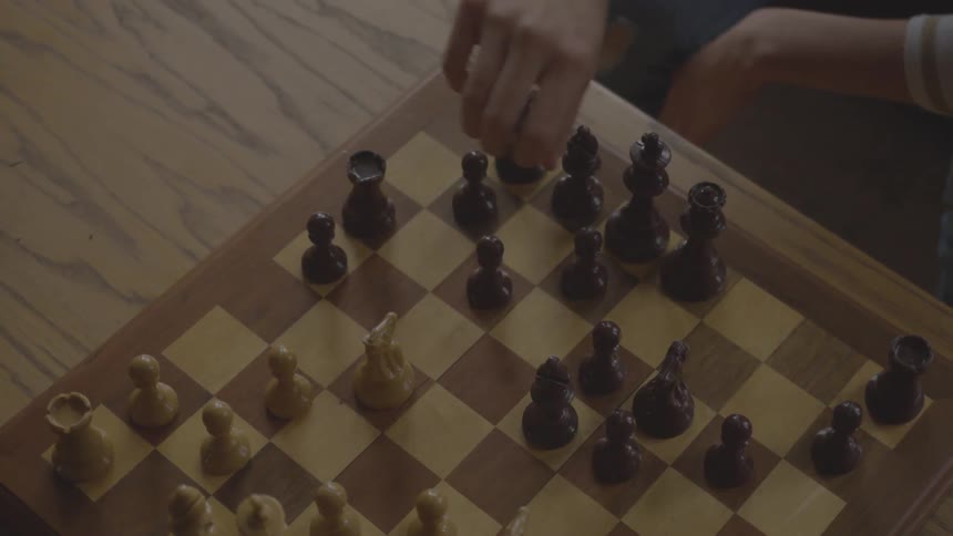 A person places a rook on a square during a chess match
