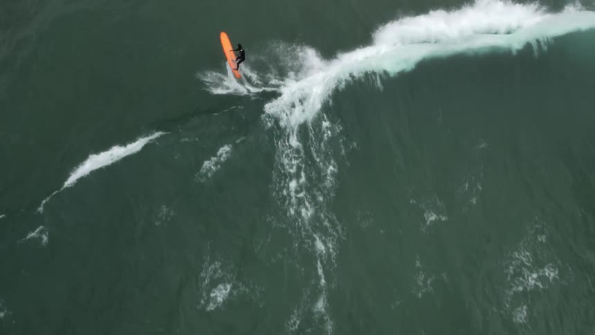 Aerial shot of a Man Surfing And Exploring Forest And Oceans In Pacific Northwest