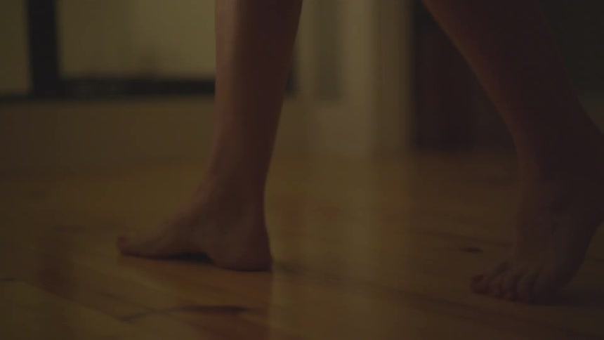 Woman walking barefoot slowly on hardwood flooring
