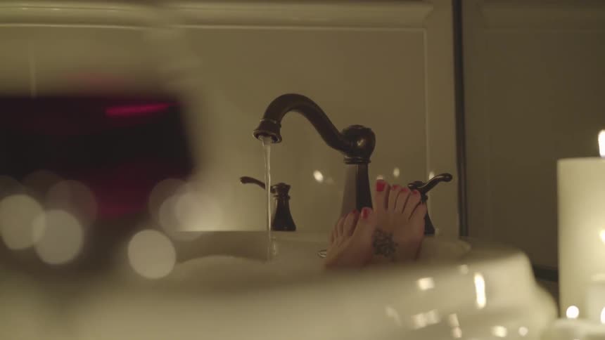 Feet resting on the edge of a bathtub
