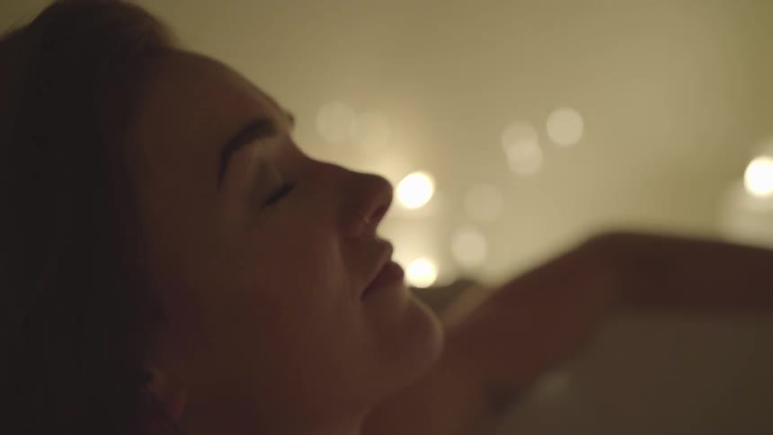 A woman is relaxing by candlelight