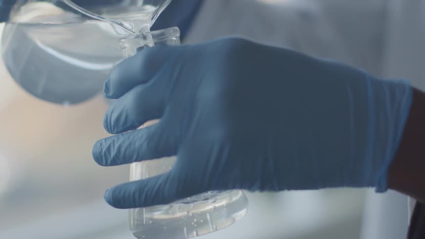 A person pours liquid into a container