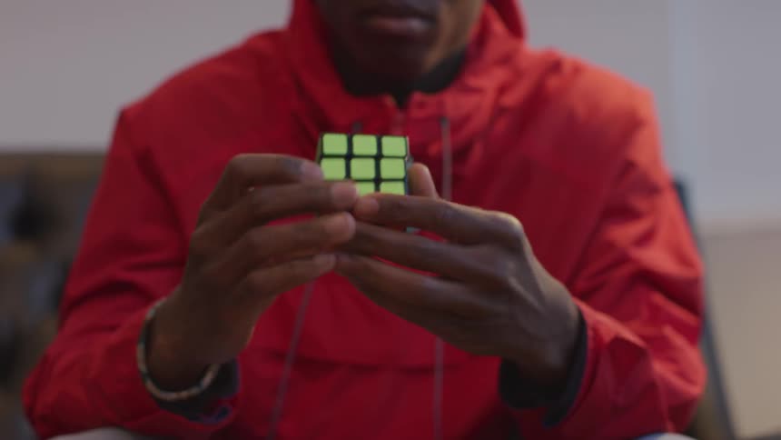 A man is finishing a Rubik's cube