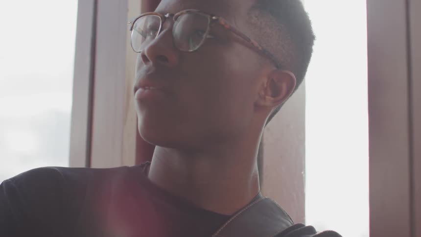 A young man leans his head back and closes his eyes