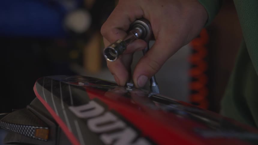A person turns a screw while holding a ratchet