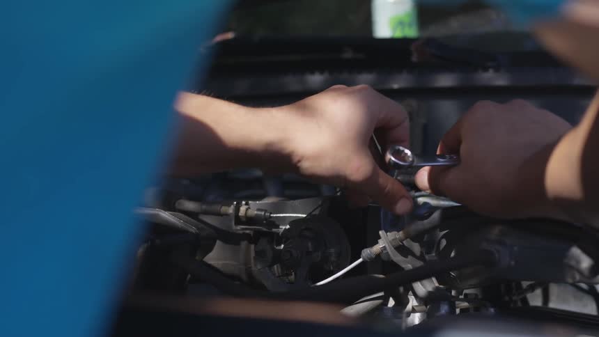 A person works on a car engine
