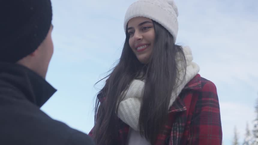 A woman smiling into a kneeling man's eyes