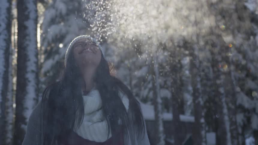 A woman throws snow into the air